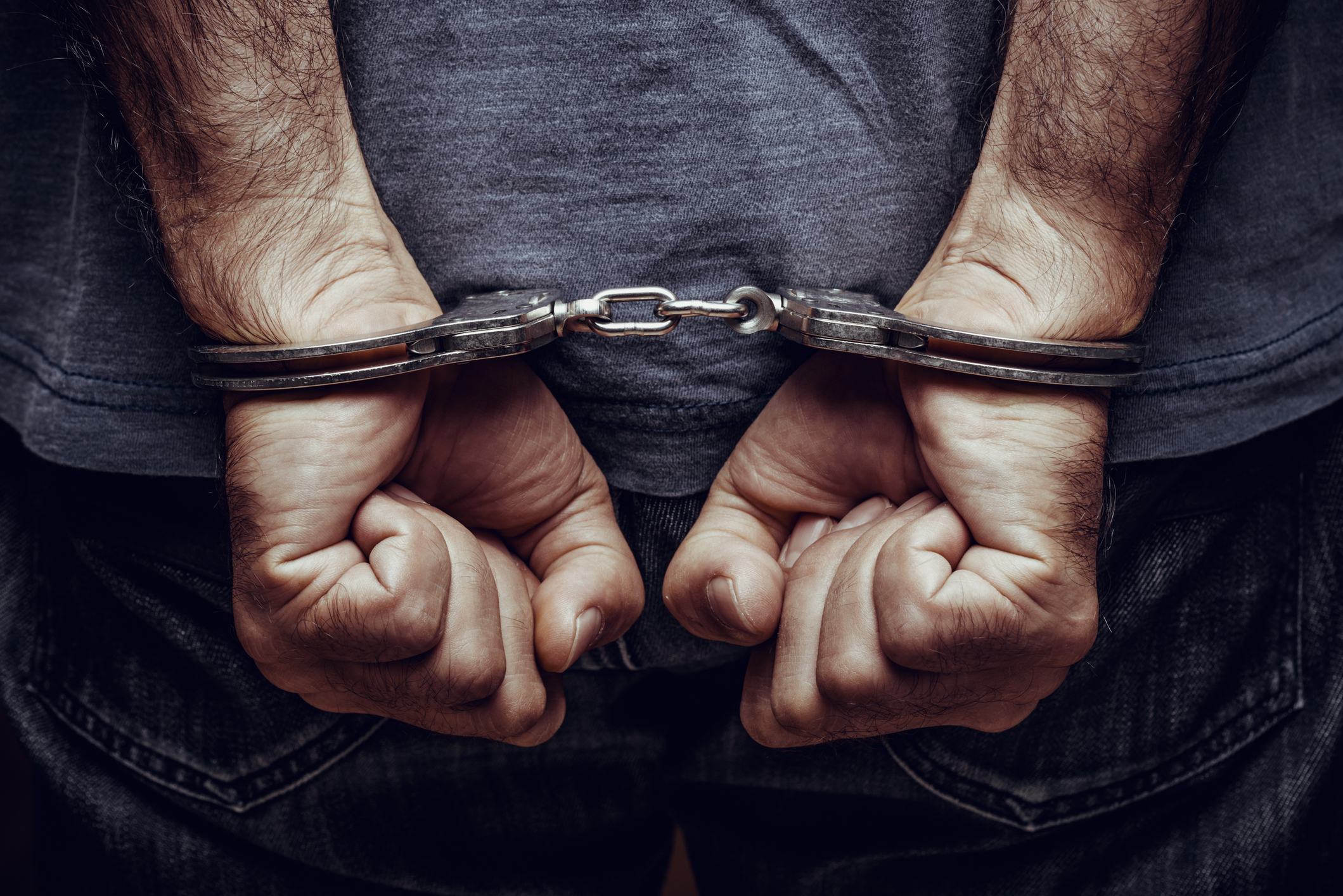 Arrested man in handcuffs in need of a criminal defense lawyer